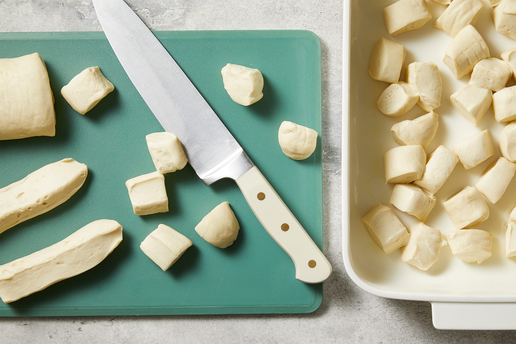 bread dough cut into pieces on a cutting board for making Monkey Bread With Frozen Bread Dough