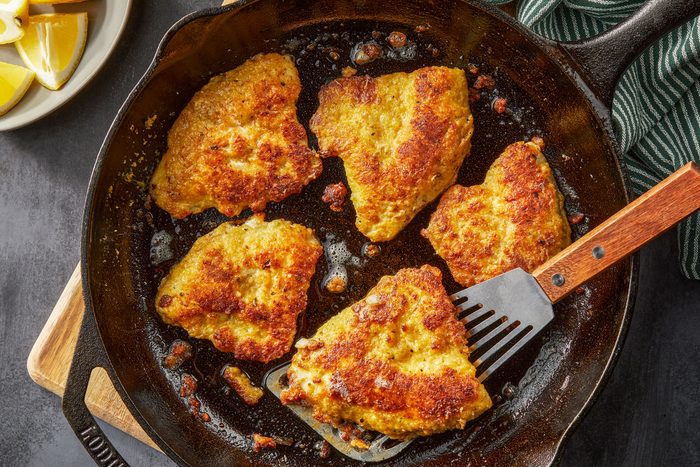 Fried Bluegill Fillets in a large skillet with a ladle