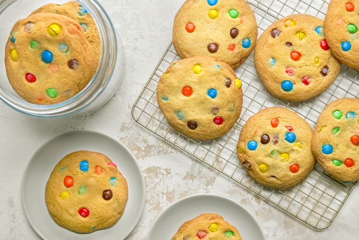 M&m Cookies placed on wire rack, in glass jar and in small plates