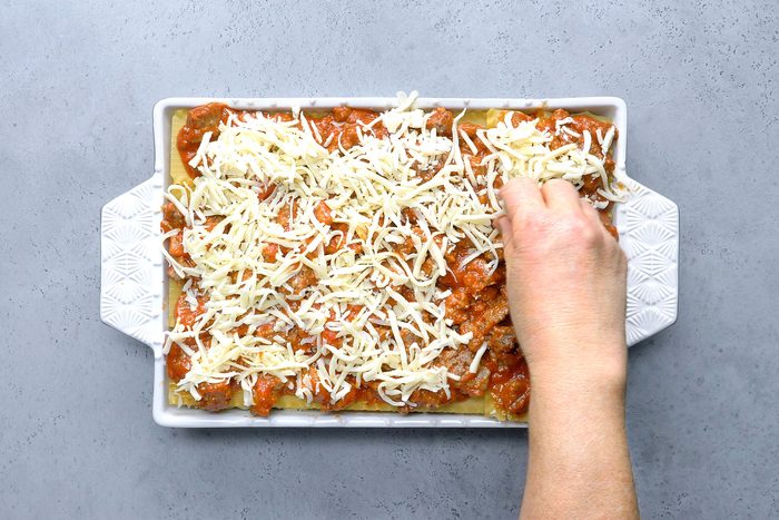 Overhead shot of top with remaining noodles; meat sauce and mozzarella cheese; refrigerate; covered 8 hours or overnight; Preheat oven to 375 degree; remove lasagna from refrigerator while oven heats; bake covered 45 minutes; bake uncovered until cheese is melted 10-15 minutes; Let stand 10 minutes before cutting; grey surface;