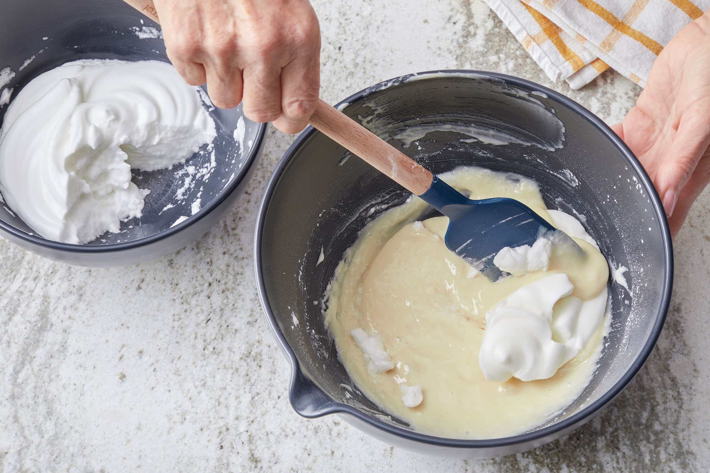 Folding fluffy egg whites in cake batter in a bowl