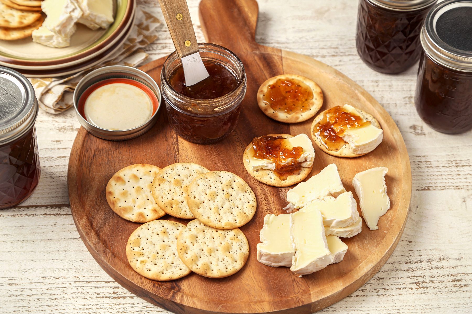Onion Jam served on a wooden board with crackers and cheese