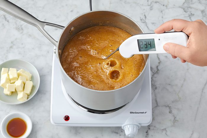 A person is checking the temperature of the mixture