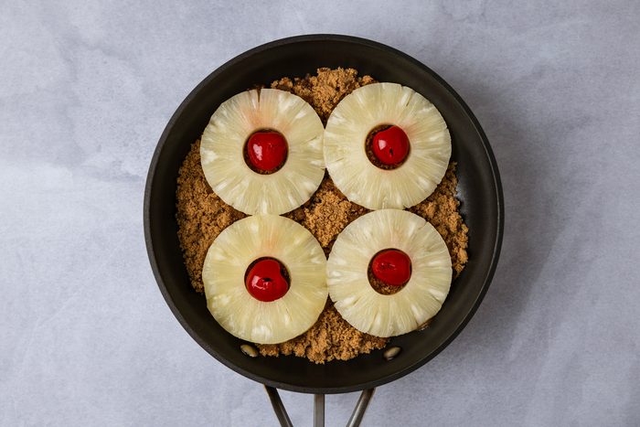 Arrange pineapple in a single layer over brown sugar; place a cherry in the center of each pineapple slice.