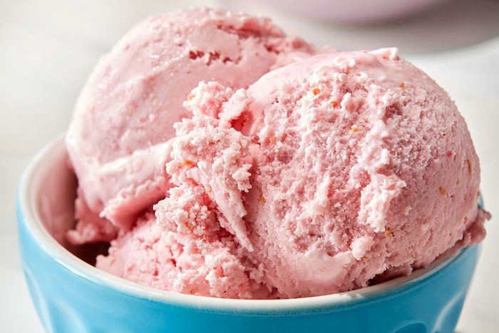 Raspberry ice cream served in a blue cup.