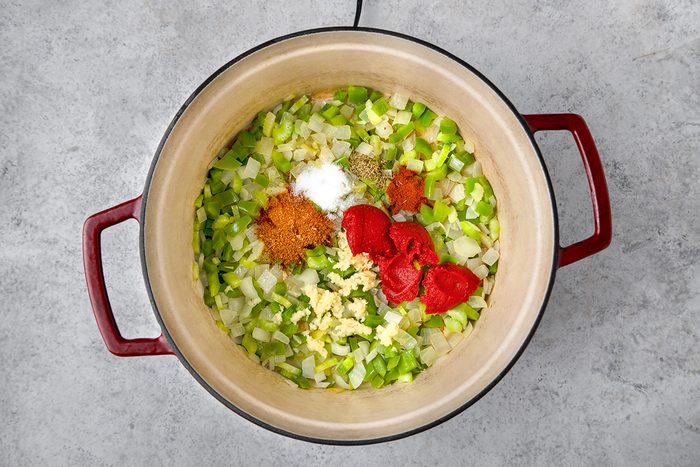 Tomato paste, garlic, Cajun seasoning, salt, paprika and thyme placed over onion and bellpapper