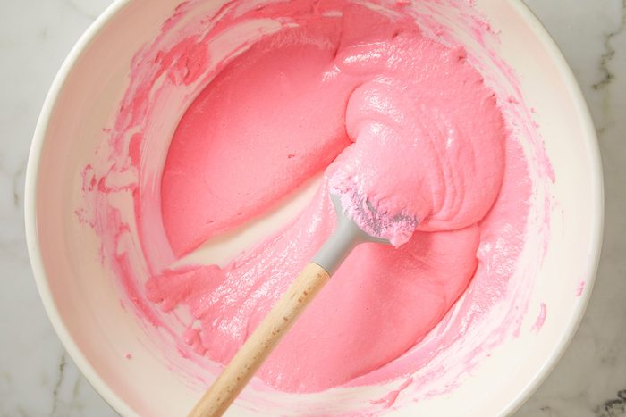 Close shot of run spatula down the center of the bowl; the line in the batter should remain visible for a moment before mixture runs back into itself; on marble surface;