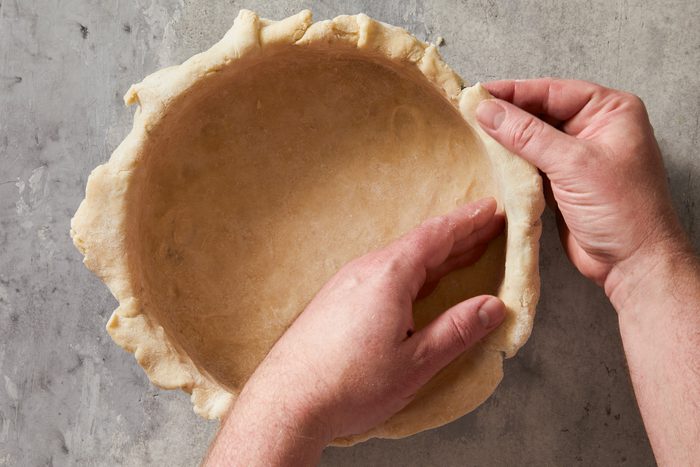 Overhead shot; Preheat oven to 350 degree; On a lightly floured surface; roll larger piece of dough to a 12-inch circle; line bottom and press up side of a greased 9-inch springform pan or deep dish pie pan; on marble surface;