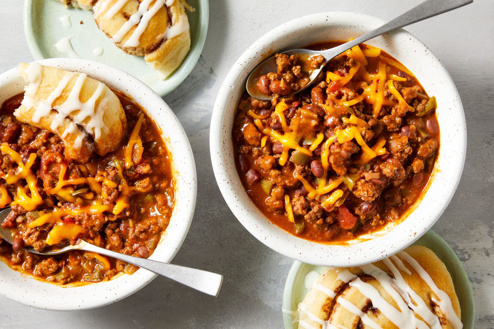 Chili And Cinnamon Rolls served in a ceramic bowls with spoon
