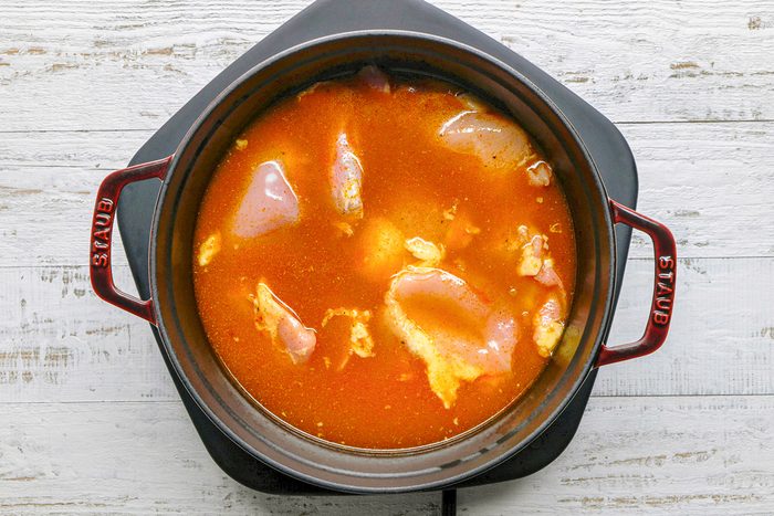 chicken added to curry mixture in dutch oven