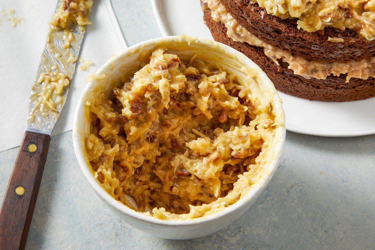 Coconut Pecan Frosting in a bowl next to cake