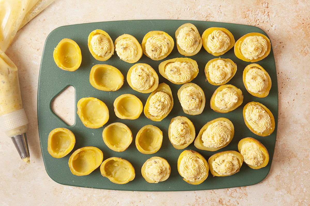 Scopped boiled potatoes being filled with filling
