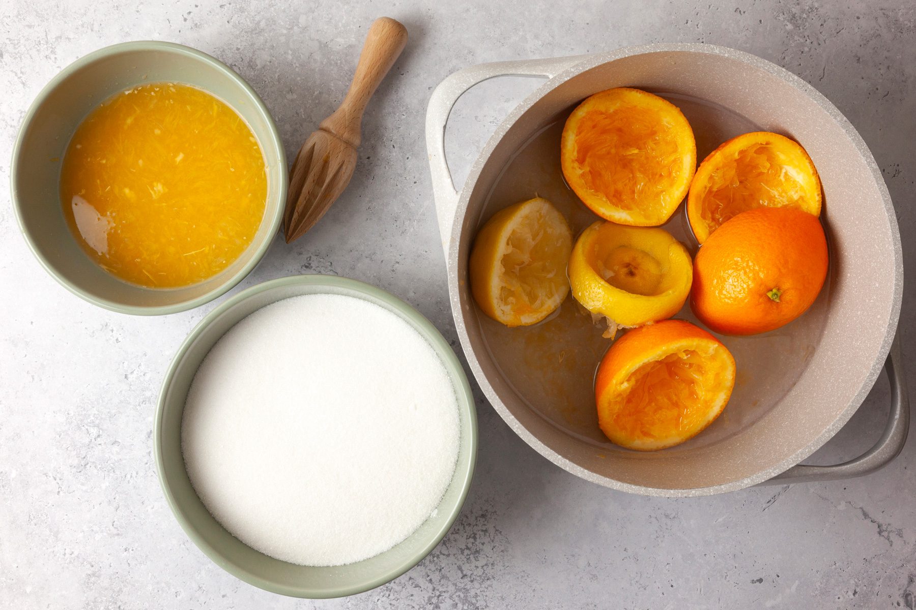 overhead shot of Orange Marmalade ingredients placed over light colored background