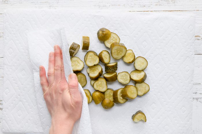 Overhead shot of drain on paper towels; blot with additional paper towels until dry; white wooden surface;