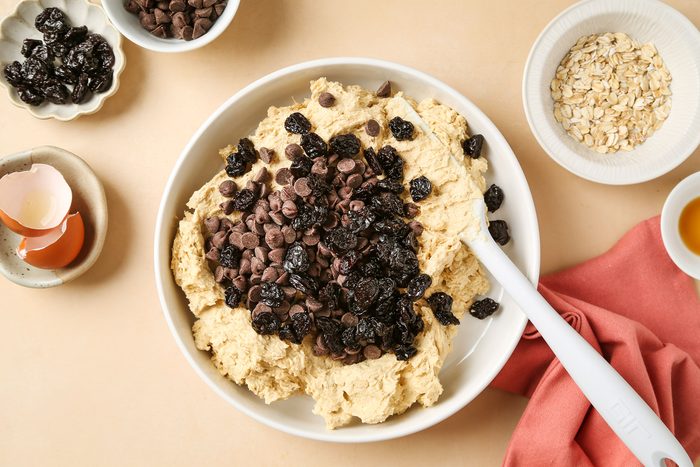 Cookies dough with chocolate chips and dried cherries in a bowl