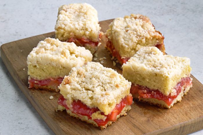 3/4 angle view shot of Strawberry Rhubarb Coffee Cake; served on a wooden tray; marble surface;