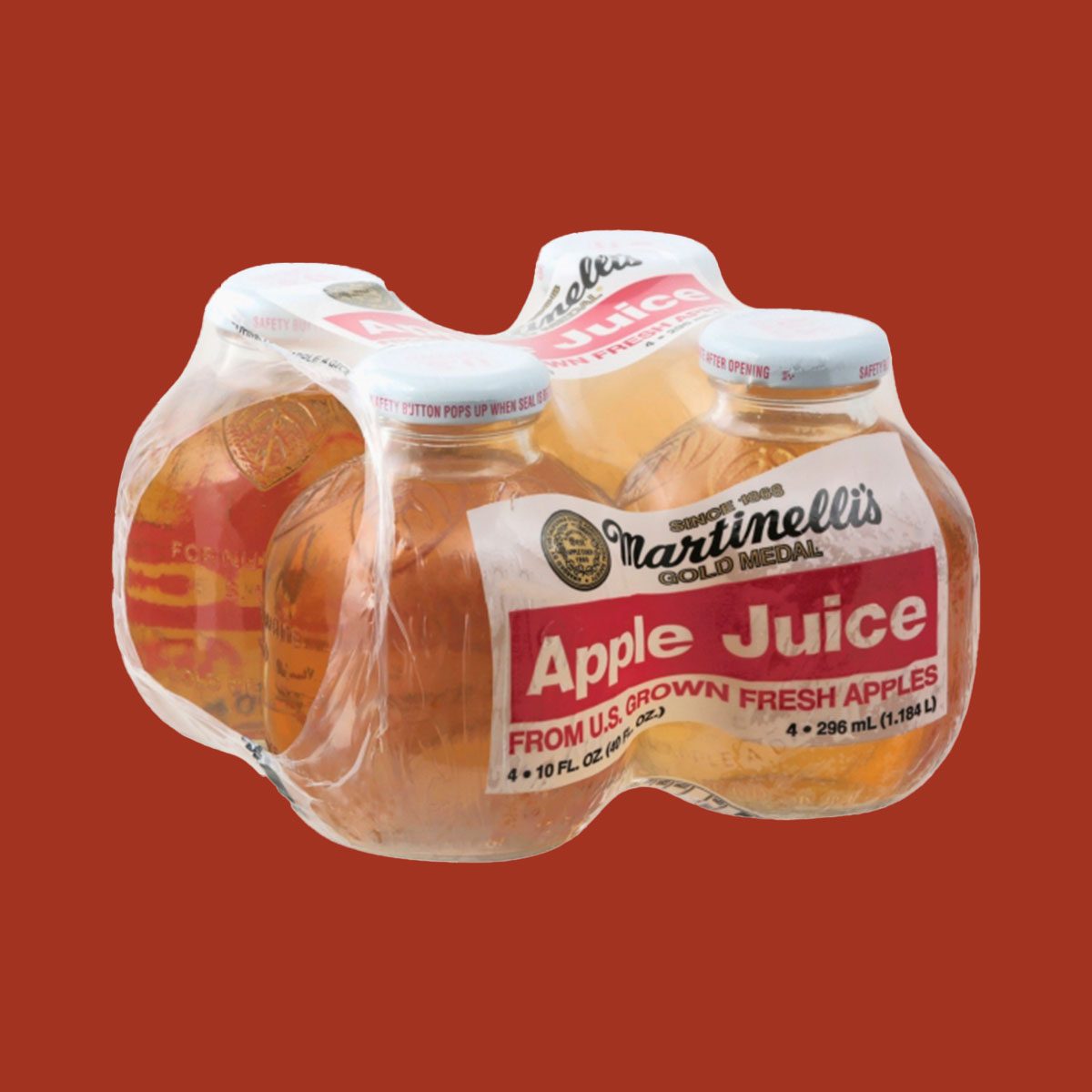 4-pack of Martinellis apple juice wrapped in plastic on red background