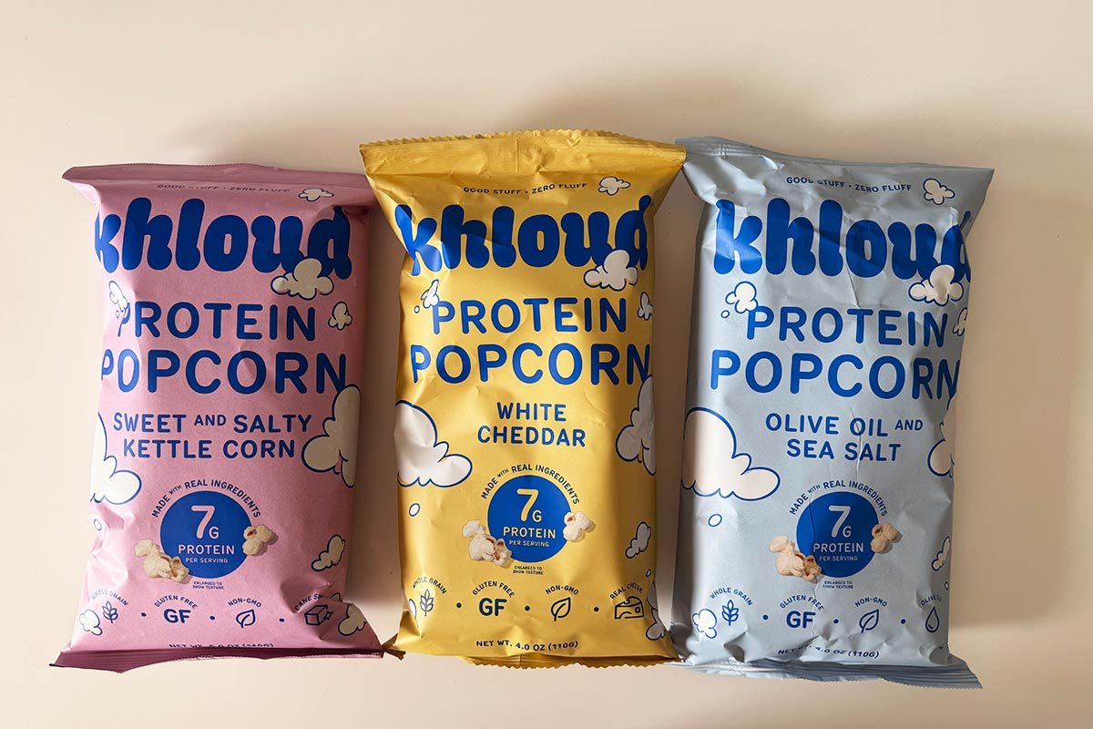 Kettle, White Chedder and Olive Oil Sea Salt flavored packages of Khloud Popcorn