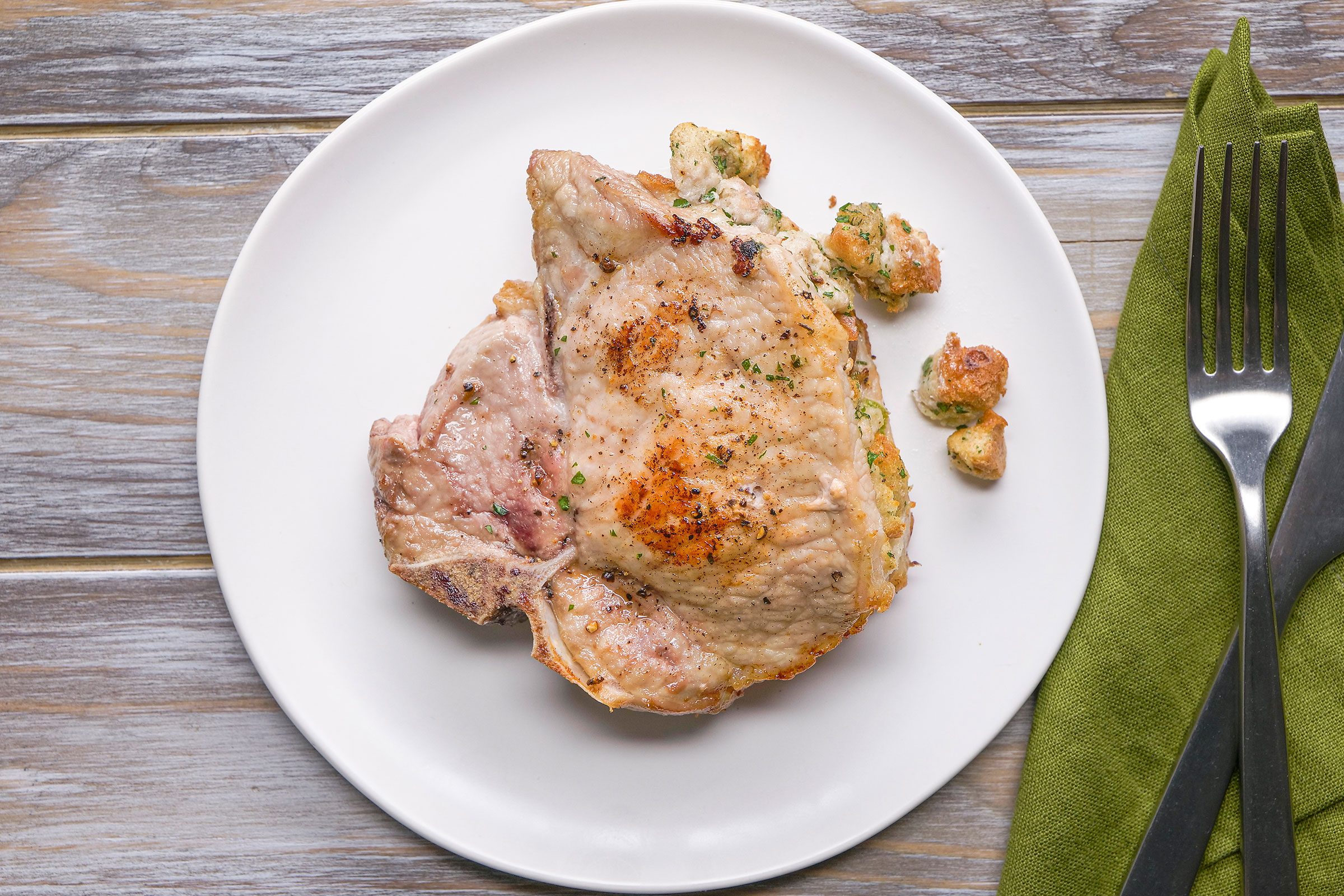 Top shot of Air Fryer Stuffed Pork Chops in a white plate on a wooden table top
