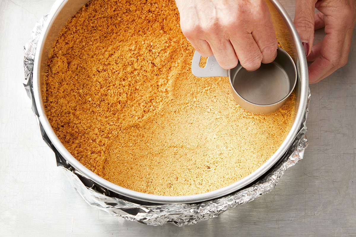 In a small bowl mix cracker crumbs and butter; show pressing onto bottom of prepared pan
