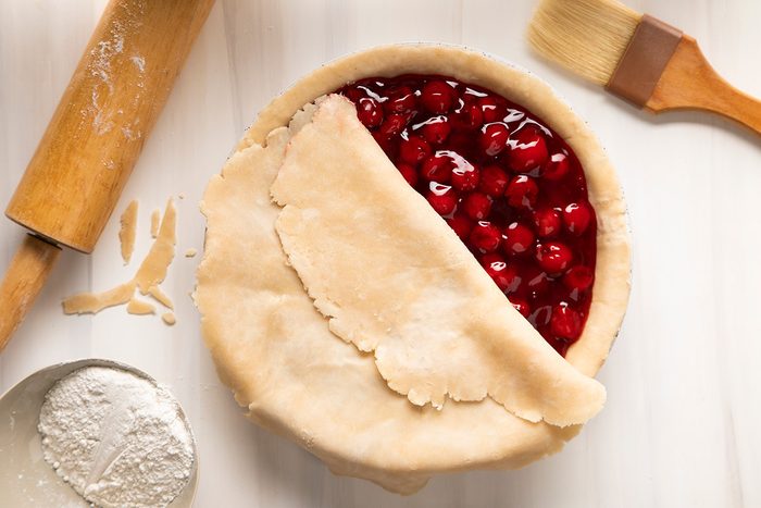 A pie with cherries and a rolling pin