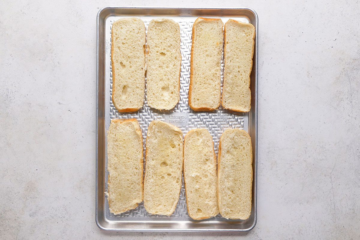 Grinder Sandwich, butter spreaded on the toast in eight slices on a sheet pan