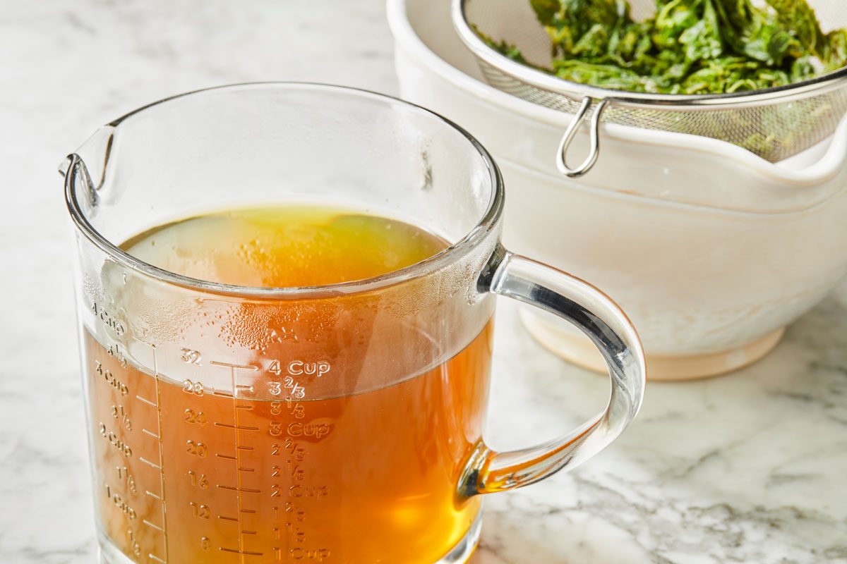 Close shot of strain; reserving 3-1/3 cups liquid (discard remaining liquid); marble surface;