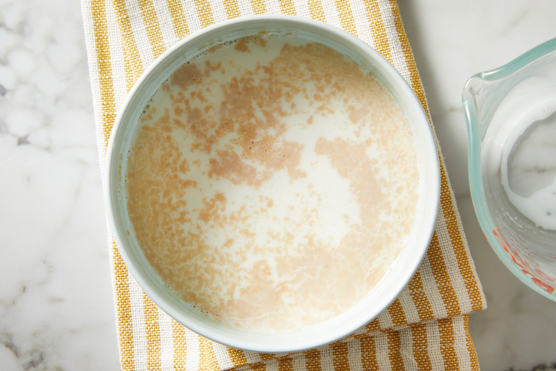 Overhead shot of Dissolve yeast in warm milk; napkin; marble surface;
