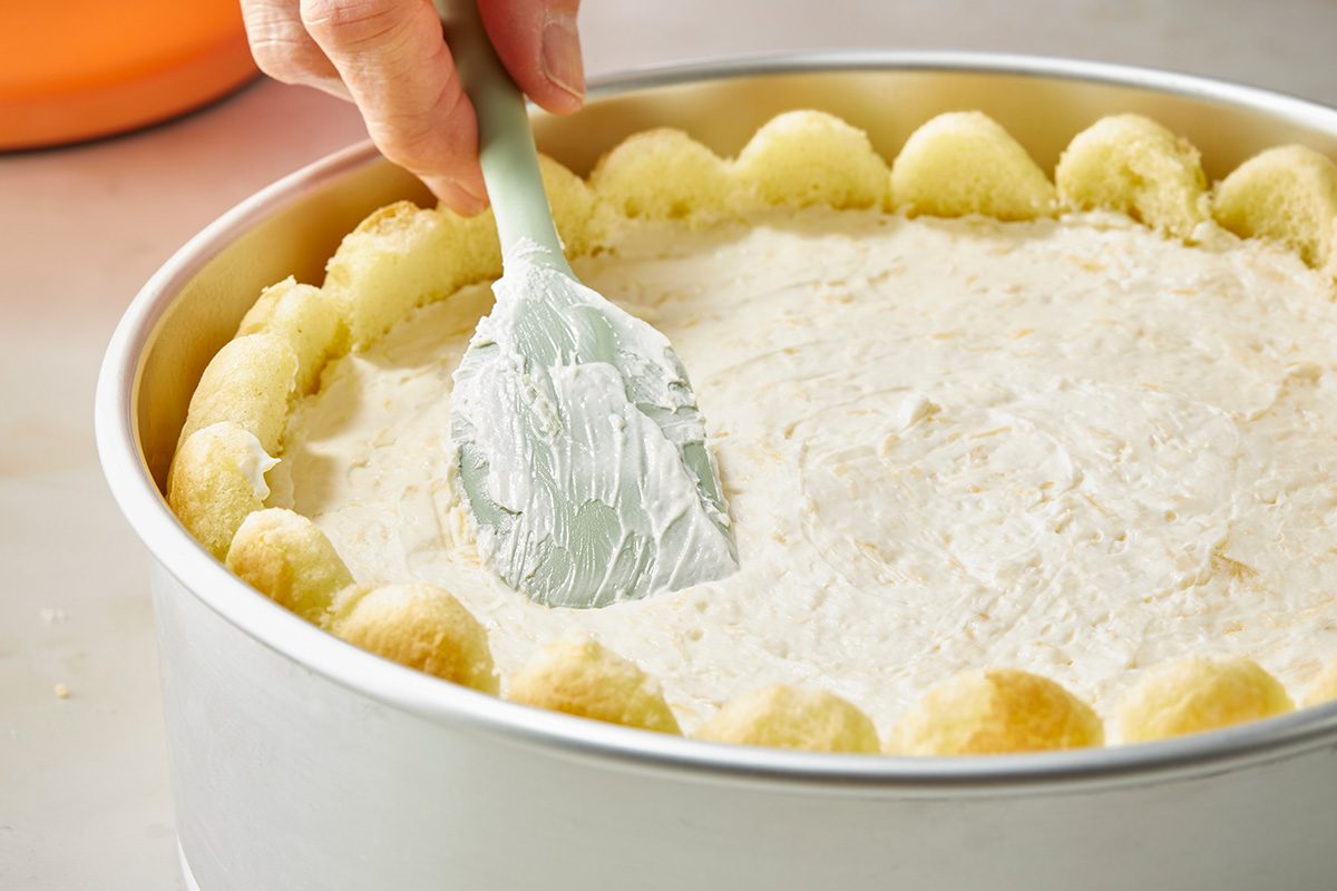 Close up shot of pour filling into pan; Cover and refrigerate for 8 hours or overnight; Carefully remove sides of pan