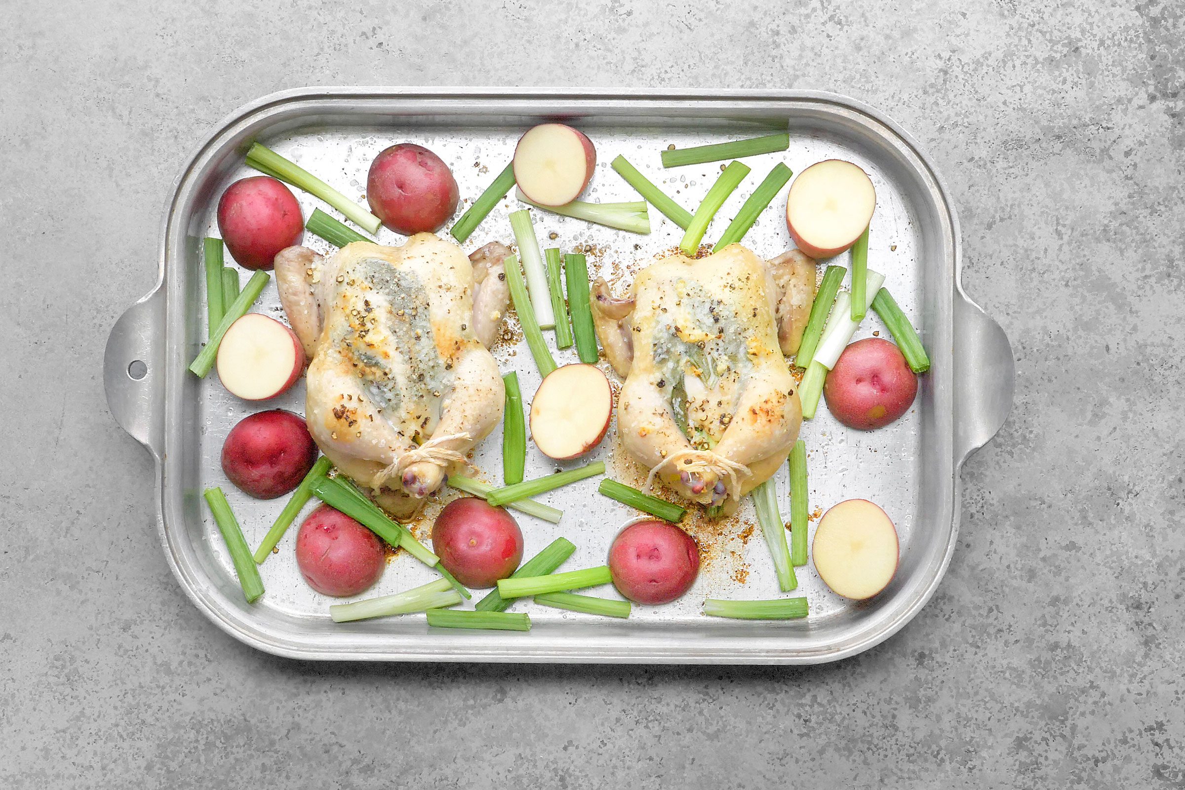 Placed the potatoes and remaining onions in the pan and all around the birds.