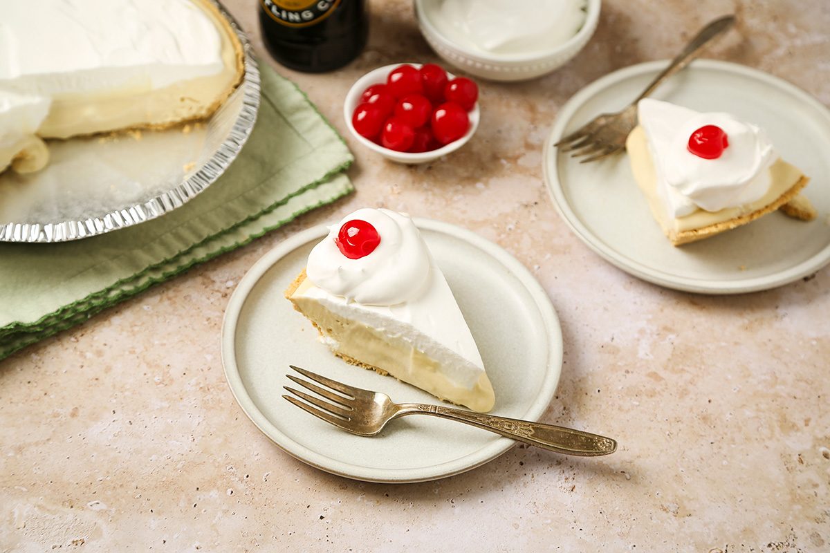 3/4 angle view shot of Root Beer Float Pie; Sliced pie with whipped topping and a cherry