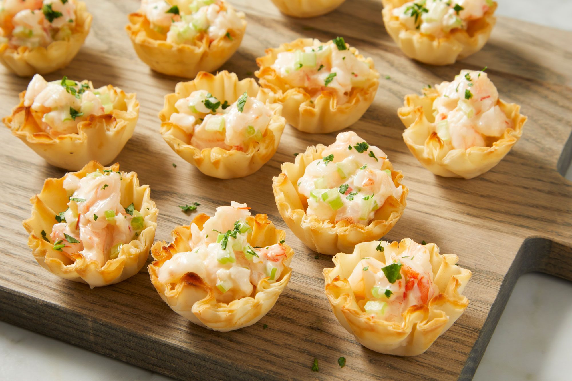 closeup shot of Shrimp in Phyllo Cups, arranged on a wooden board