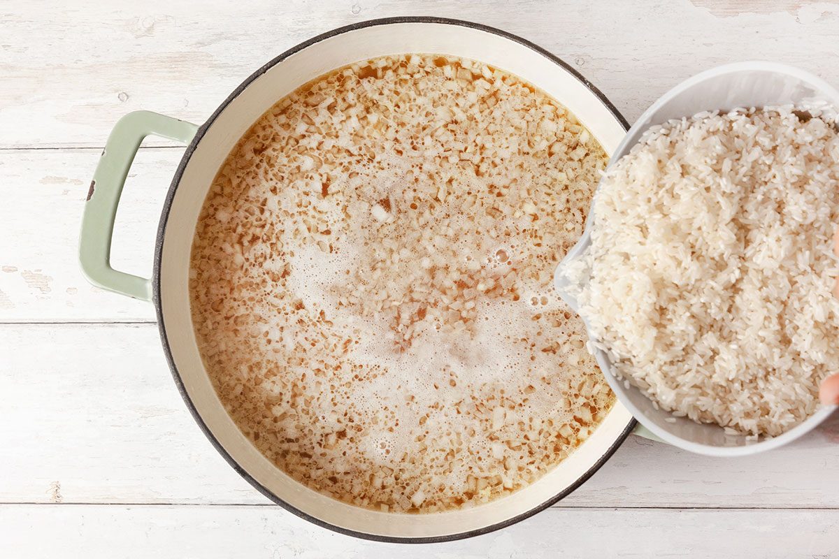 Rice is being added in a stock pot