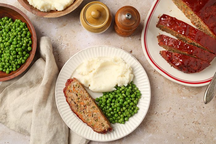 Bison Meat Loaf served on a plate with peas and mashed potatoes