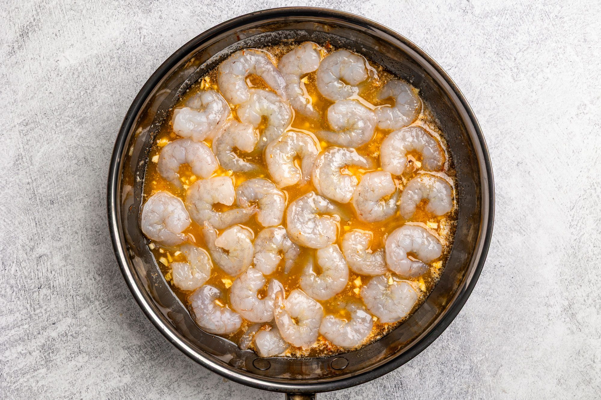 In a large skillet saute the shrimp; garlic; salt and cayenne in butter until the shrimp turn pink