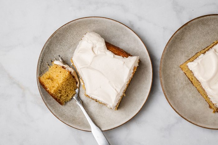Overhead shot of Root Beer Float Cake served on two brown ceramic plates with fork; all set on a marble surface