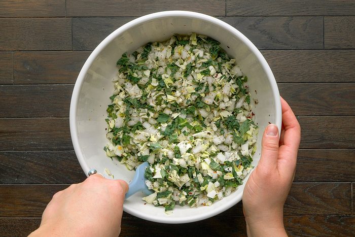 Overhead shot on a on a table. In a large white bowl combine the remaining ingredients using a spatula.