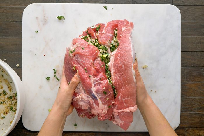 Overhead shot on a white cutting board on a table. Place any remaining filling in the center of the ham.