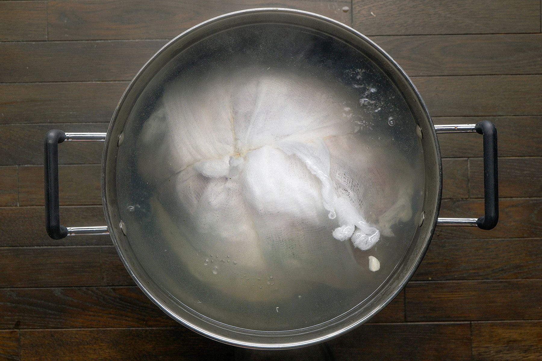 Overhead shot on a table. Fill a large stock pot with enough water to cover the ham; bring to a boil; Add ham to pot.