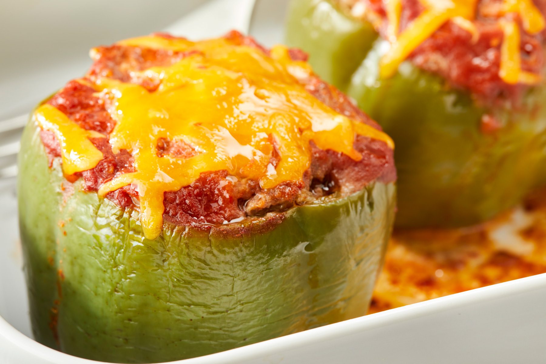 Close shot of sprinkle with remaining cheese; return to the oven for 5 minutes or until cheese is melted; all set on a cream-colored wooden surface;