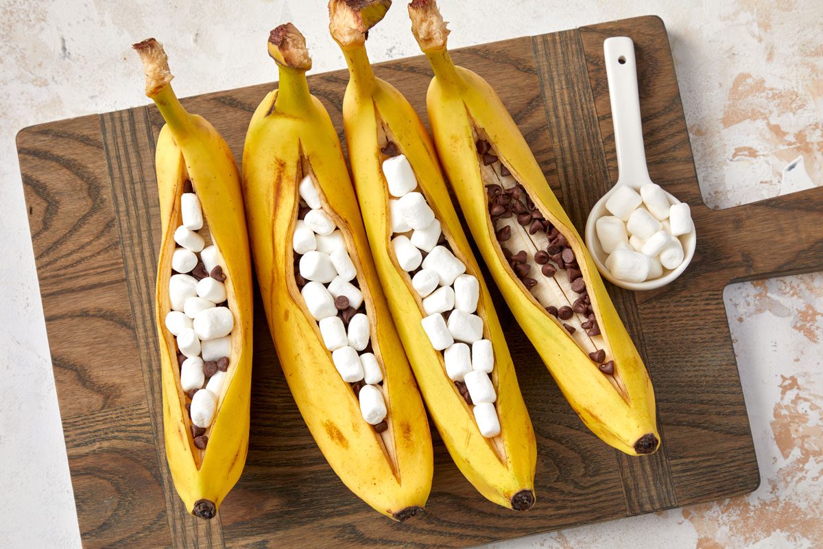 Overhead shot of Fill each with 2 teaspoons chocolate chips and 1 tablespoon marshmallows; wooden cutting board; all set on a marble surface;