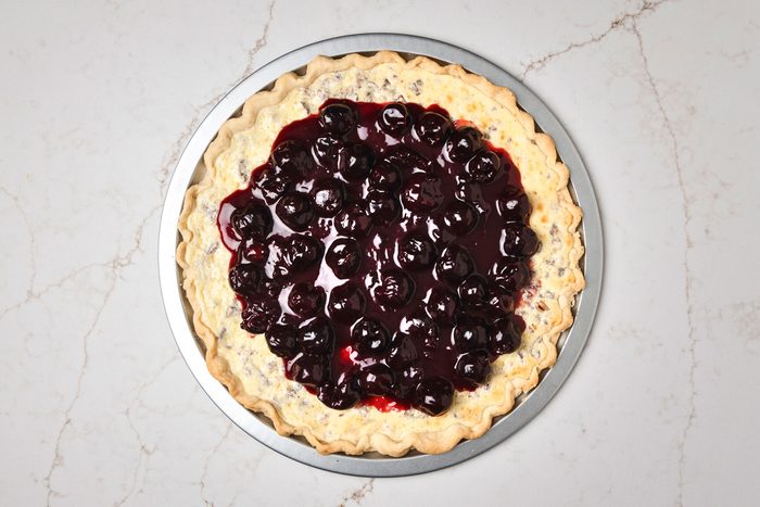 Overhead shot of spread over cream cheese layer; all set on a white texture marble surface