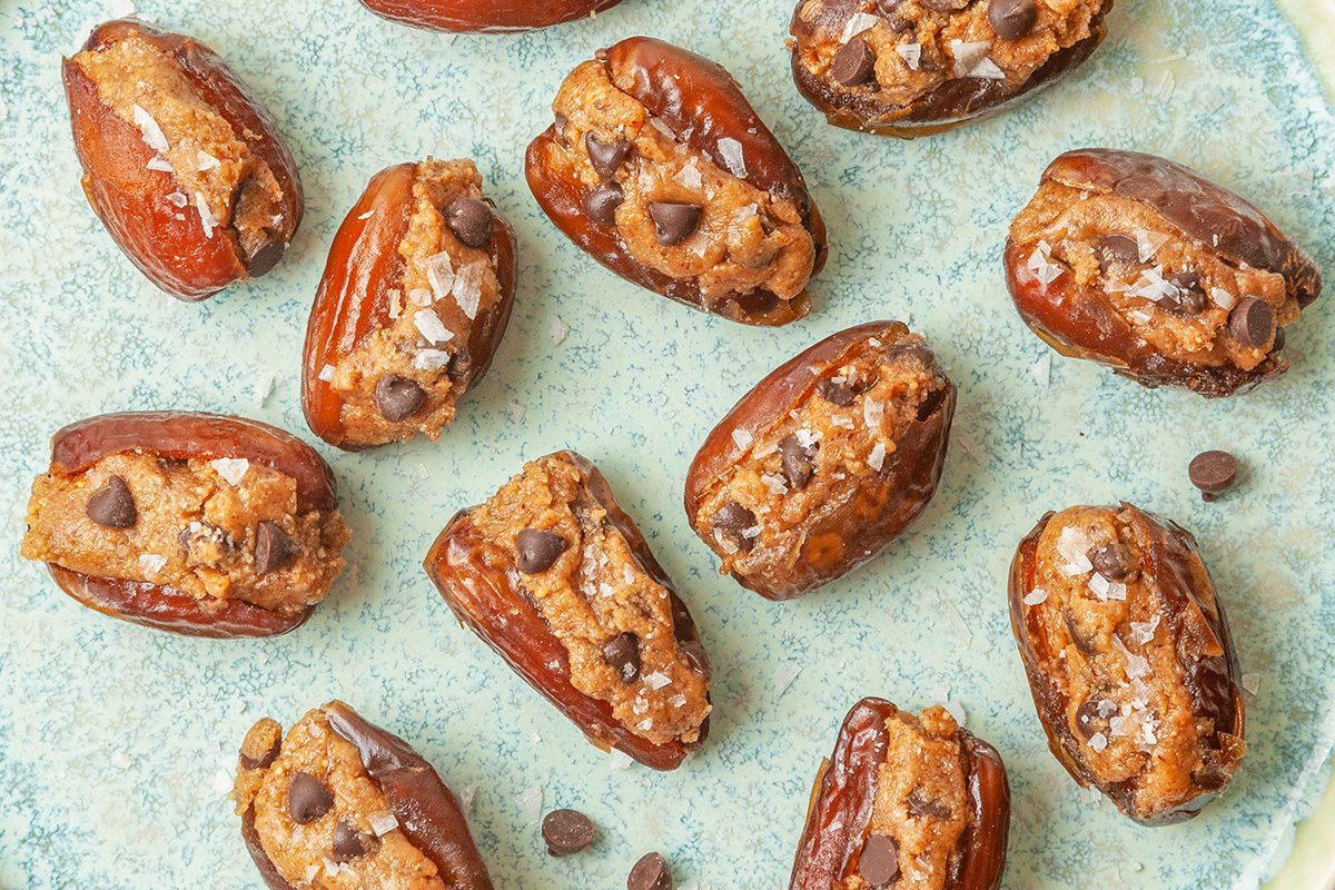 Closeup shot of Cookie Dough-Stuffed Dates; served ona ceramic plate; garnish with flaky sea salt just before serving;
