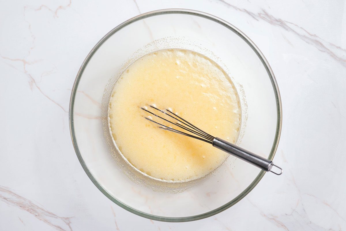 Sugar with the lemon, lime and orange juices being mixed in a large bowl