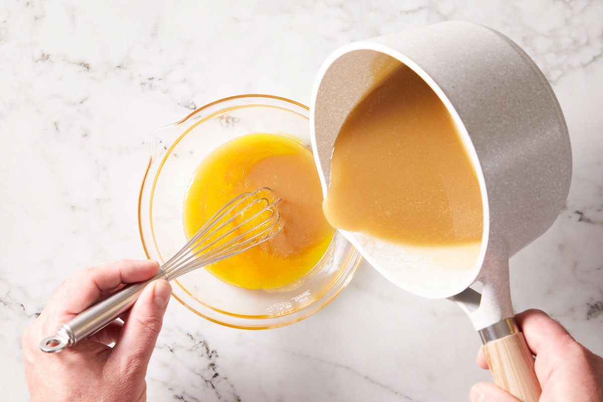 In a small bowl, whisk a small amount of hot mixture into egg yolks