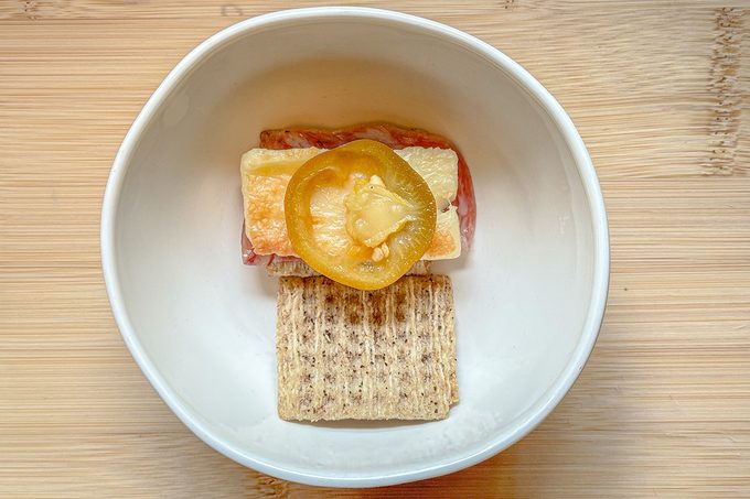 Hot Cheese layered in between crackers along with meat and spreads in a bowl