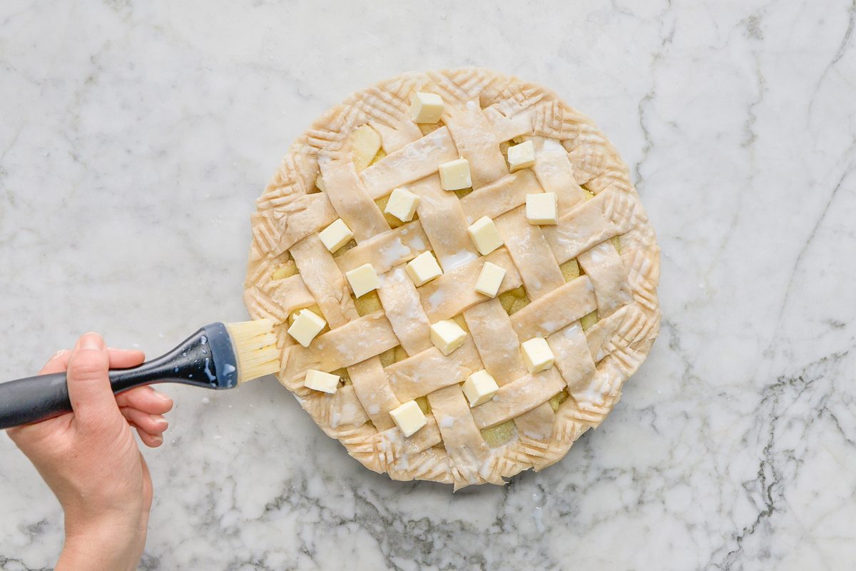 brushing top of pie with milk