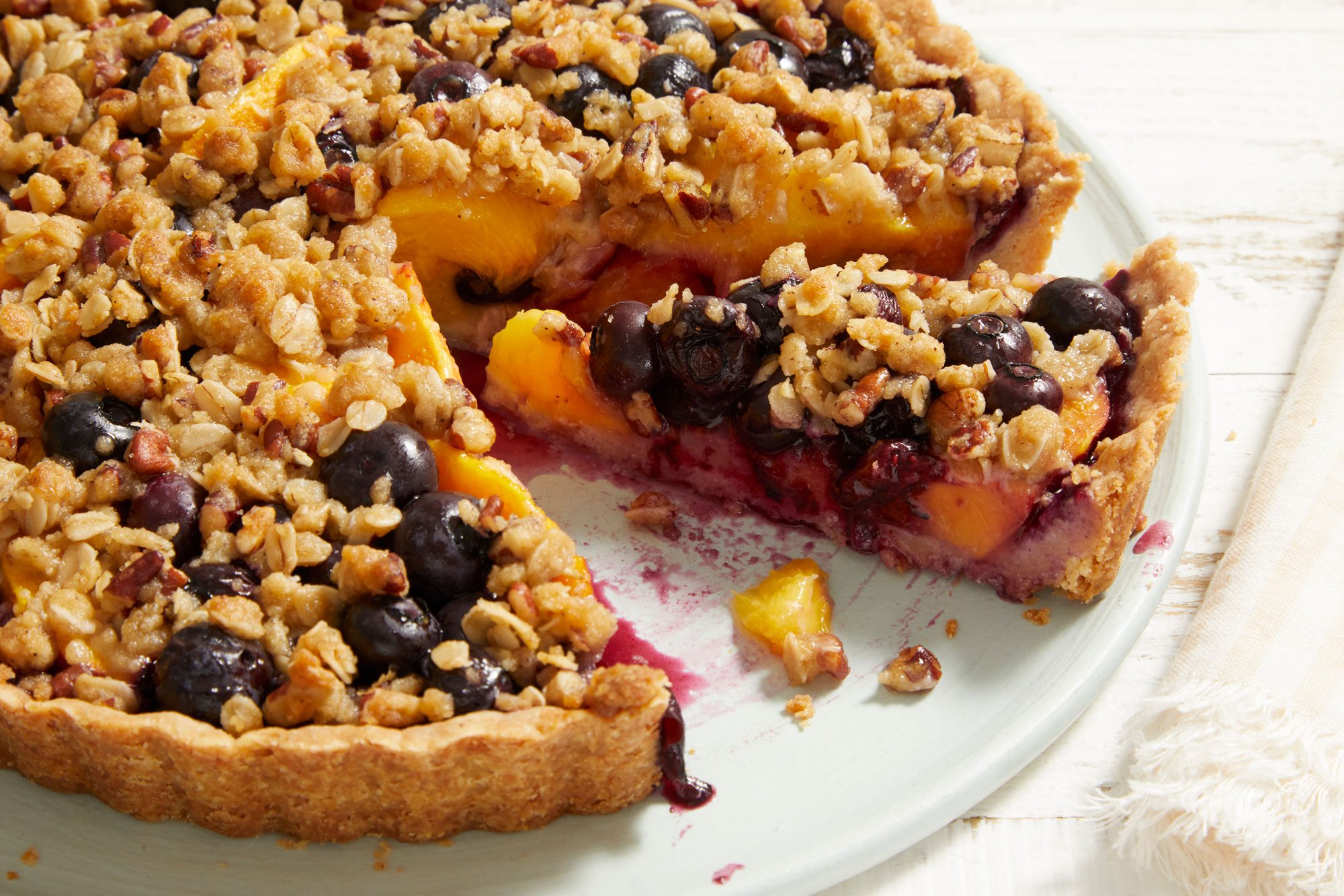 Close up shot of Peach-Blueberry Crumble Tart