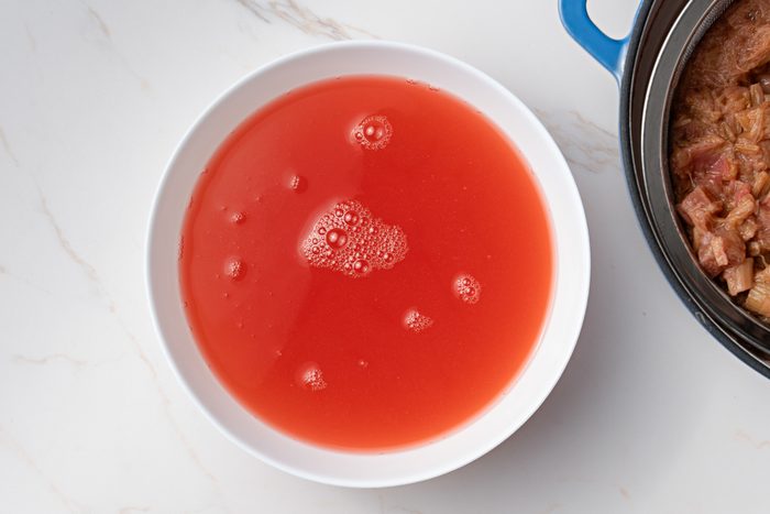 drained liquid from boiled rhubarb in a bowl