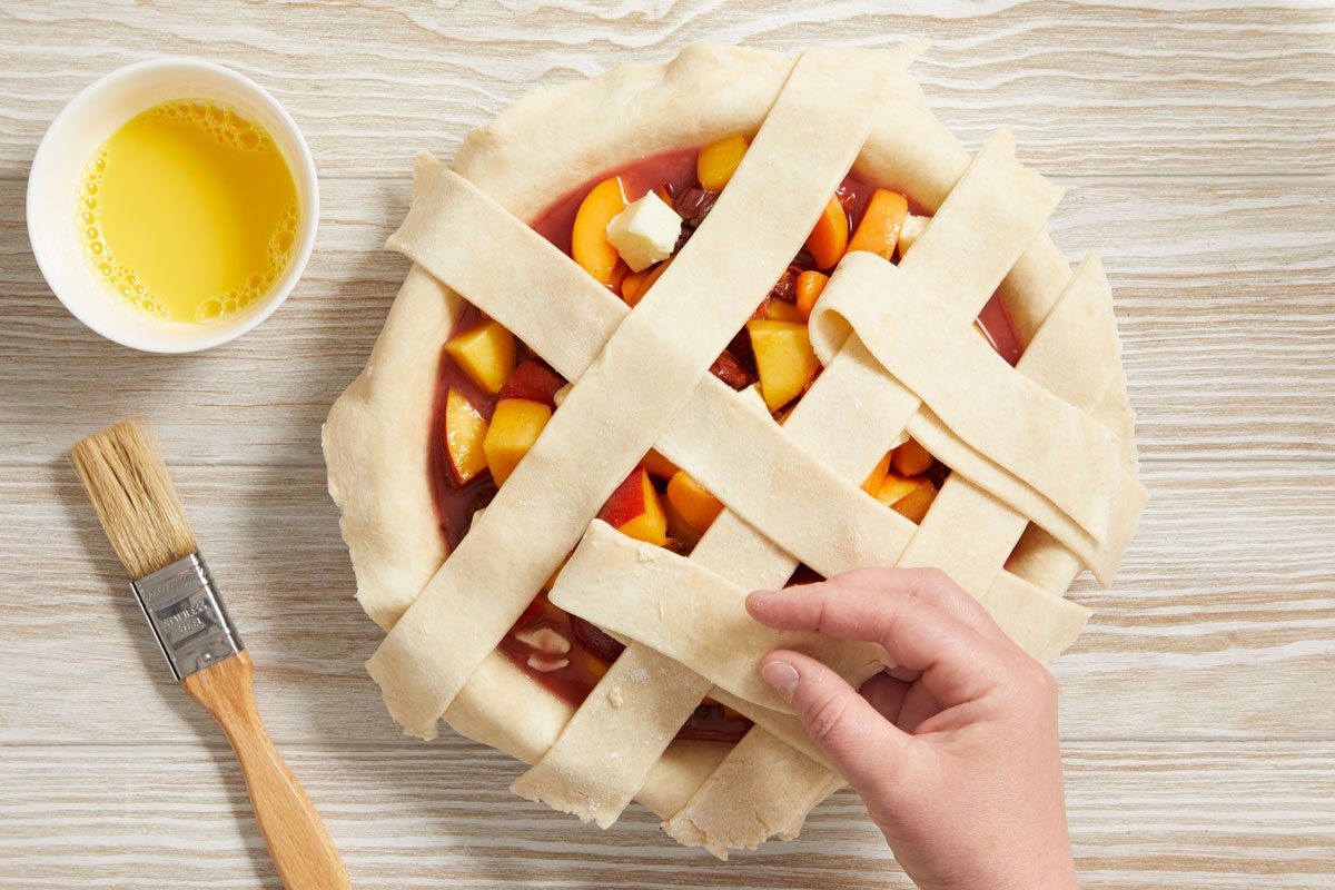 Add filling; dot with remaining butter. Roll out remaining dough; make a lattice crust. Trim, seal and flute edge.